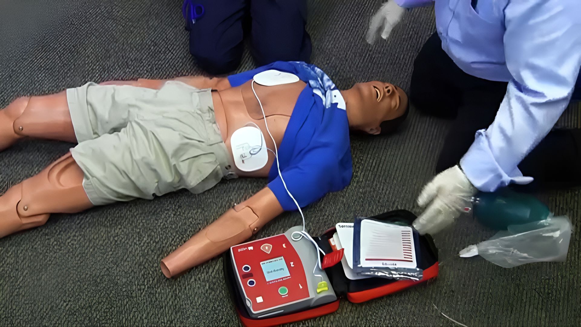 man demonstrating how to use AED